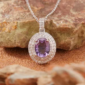 Macro di un elegante ciondolo ovale in ametista incastonato in argento S925