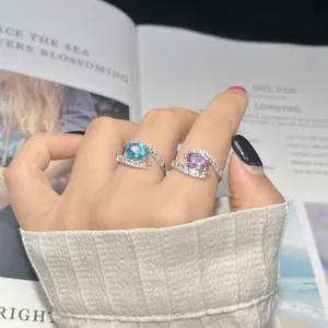 Close-up of S925 sterling silver rings with blue and purple gemstones on hand
