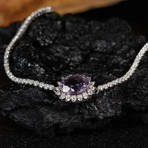 Gros plan d'un élégant bracelet en améthyste violette sur pierre de lave noire