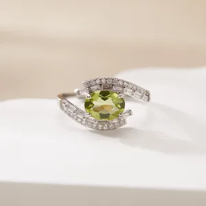 Close-up of S925 silver ring featuring an oval green gemstone and baguette stones.