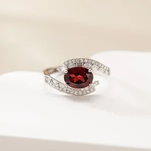 Close-up of elegant S925 sterling silver ring with oval red garnet and cubic zirconia stones