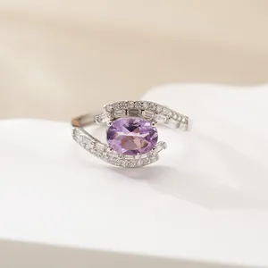Close-up of elegant S925 silver ring with oval purple amethyst and pave clear stones