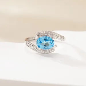 Macro detail of S925 sterling silver ring with oval blue gemstone and cubic zirconia.