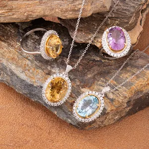 Close-up view of oval citrine, amethyst, and topaz jewelry set displayed on natural rock texture.