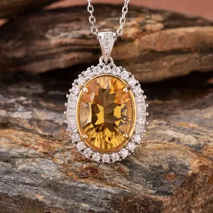 Detailed view of an oval millennium cut citrine pendant surrounded by clear crystals