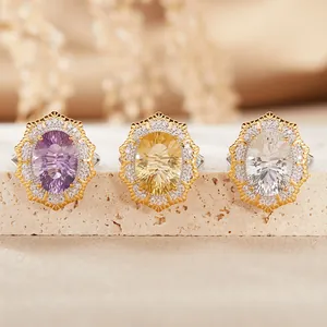 Three vintage Victorian style oval gemstone rings with halo settings on stone base
