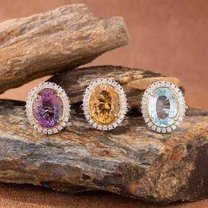 Close-up of three exquisite millennium-cut citrine, amethyst, and topaz halo rings on rocks