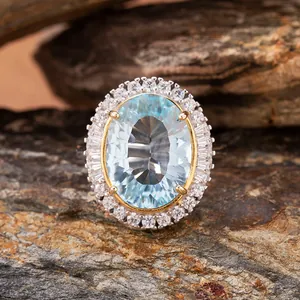 Macro detail of oval blue topaz ring with millennium cut on natural rock background
