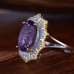 Close-up of a Victorian style oval amethyst ring with ornate double halo silver setting