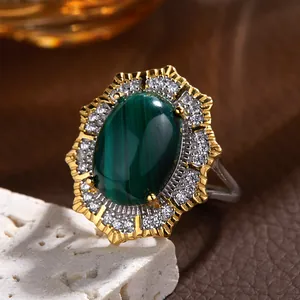 Macro detail of a vintage Victorian style ring with a green oval stone and zircon halo.