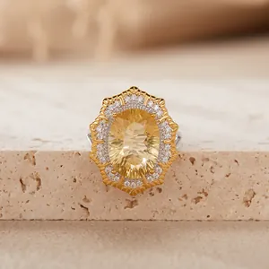 Macro view of Victoria style oval yellow gemstone ring with silver double halo