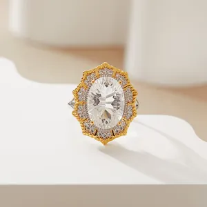 Macro view of Victorian style oval white gemstone ring with ornate gold halo setting