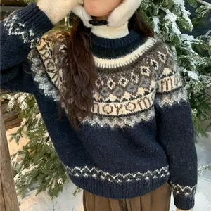 Close-up of women's navy Fair Isle knit pullover sweater in winter snow scene