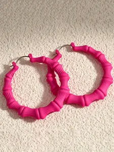 Nahaufnahme von übergroßen neonpinken Bambus-Creolen für Hip-Hop-Tanz-Styles
