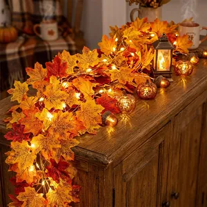 Warme herfst esdoornblad slinger met LED-verlichting op een houten kast