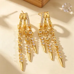 Detailansicht goldener Dreifach-Creolen mit Zirkonia-Besatz und spitzen Anhängern.