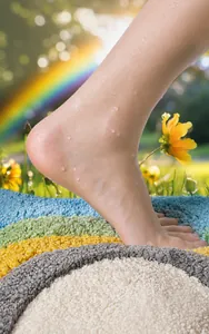 Detailed close-up of a bare foot on a colorful tufted bath mat with soft absorbent texture.
