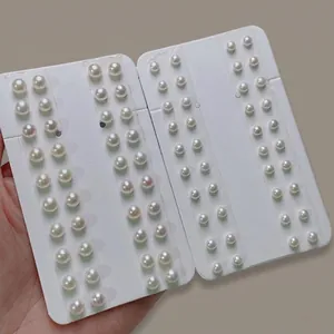 Close-up detail of multiple white freshwater pearls neatly arranged on display cards