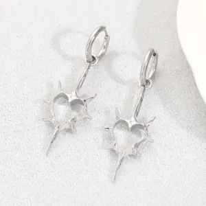 Macro view of gothic punk silver heart hoop earrings with spiked rivet accents