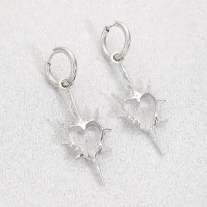 Detailed macro shot of silver gothic punk spiked heart earrings on textured fabric
