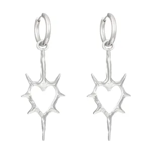 Detail shot of gothic silver thorny heart earrings featuring a unique punk rivet design