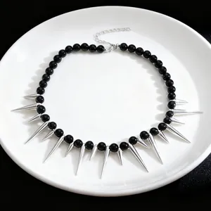 Detailed view of a punk gothic necklace with black beads and sharp silver spikes.