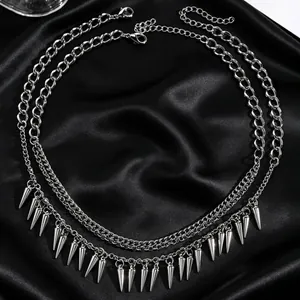 Close-up detail of silver-toned gothic punk spike necklaces on a black satin background