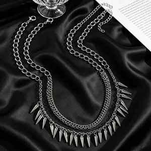 Detailed view of a gothic punk silver layered necklace with sharp metal rivet spikes