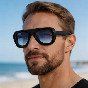 Close-up of men's thick-frame aviator sunglasses with blue gradient lenses on beach.