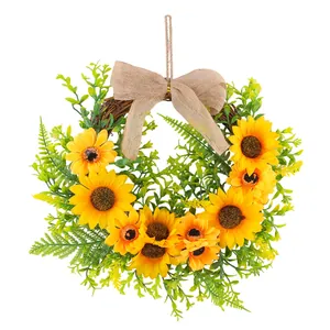 Vibrant artificial sunflower wreath with green leaves and a burlap bow for door decor