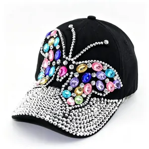 Detailed view of a black baseball cap featuring a vibrant rhinestone butterfly design.