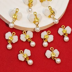 Close-up of bow-knot pearl pendants with faux jade stone for DIY jewelry making.