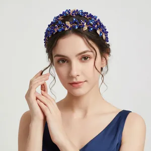 Detailed close-up showing a vintage blue crystal headband with golden hollow metal leaves