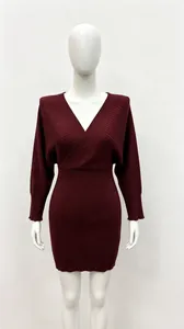 Détail d'une robe en tricot bordeaux avec col en V croisé et manches chauve-souris.