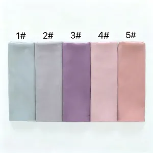 Detalle macro de cinco bufandas de gasa de diferentes colores para mujer dobladas ordenadas