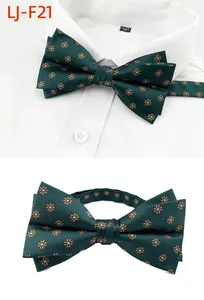 Vue détaillée du nœud papillon vert foncé à motif floral orange pour costumes de mariage.