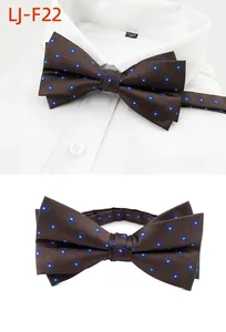 Détail d'un élégant nœud papillon marron à motif floral bleu pour tenue de mariage formelle