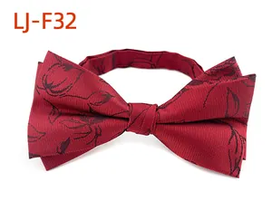 Gros plan d'un nœud papillon bordeaux avec motif floral noir montrant la texture