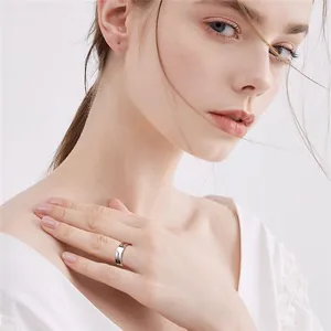 Female model wearing a polished silver stainless steel ring showing a minimalist puzzle design