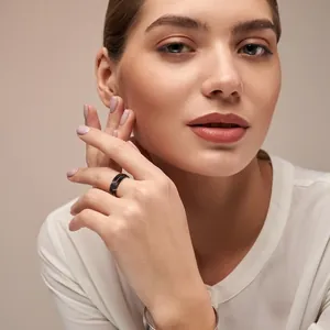 Modern black titanium steel ring for women in a professional lifestyle portrait.