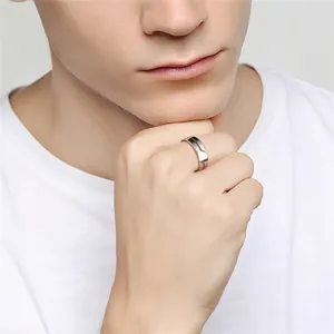 Close-up macro view of a minimalist silver polished stainless steel ring on model's finger