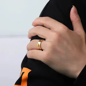 Detailed close-up of a minimalist gold-plated titanium steel ring worn on a model's finger