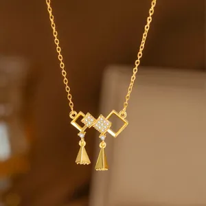 Elegante collar de oro con colgante geométrico y detalles de cristal brillantes.