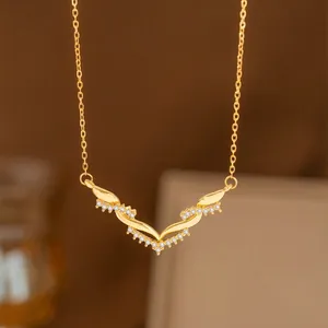 Collar con colgante de espiga de laurel dorado con piedras brillantes y diseño en V