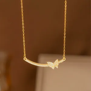 Elegante collar de mariposa en tono dorado con cristales brillantes, estilo minimalista.