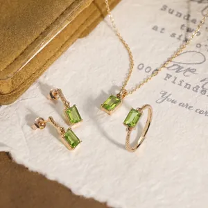 Nahaufnahme eines geometrischen S925 Silberschmucksets mit grünen Peridot-Edelsteinen.