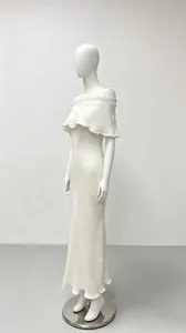 Elegant off-the-shoulder white knit maxi dress with ruffle detail shown on mannequin stand.