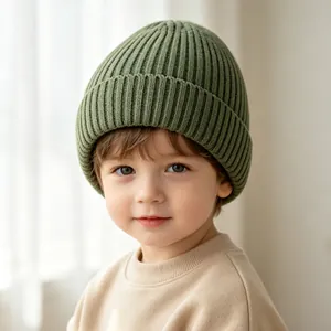 Nahaufnahme eines Kleinkindes mit einer weichen, grünen, gerippten Strickmütze für Babys