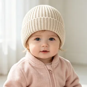 Nahaufnahme eines Babys mit einer warmen, beige gerippten Strickmütze für Herbst und Winter.