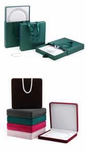 Detailansicht verschiedener bunter Samtschmuckboxen und hochwertiger grüner Geschenktüten